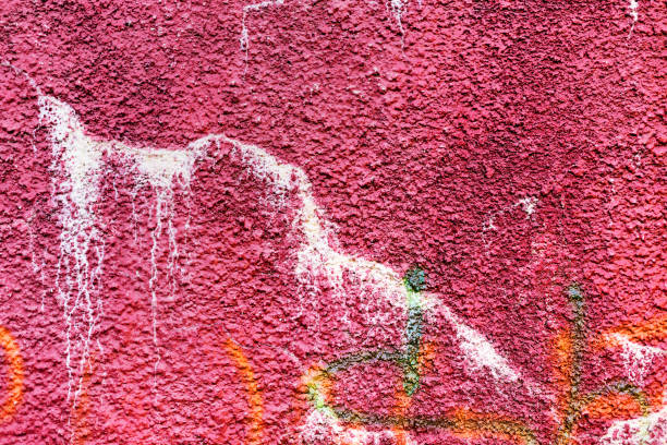 istock Authentic textured background old wall, hooligans stained with paint. Landscape style. Grungy concrete surface, windows with bars. Great background or texture. 1255210971