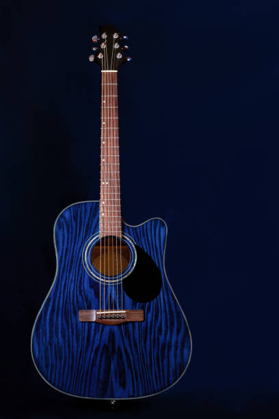 istock Dreadnought acoustic guitar on a blue background in the dark. Copy space 1255213347