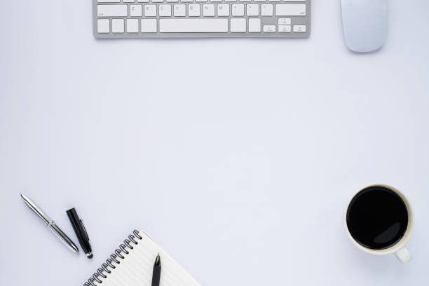 istock Top view above of White office desk table with keyboard, notebook and coffee cup with equipment other office supplies. Business and finance concept. Workplace, Flat lay with blank copy space. 1255216657