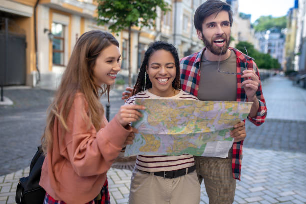 istock Three friends with map on city street 1255218880