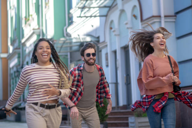istock Guy and two girls running bouncing down the street 1255218887