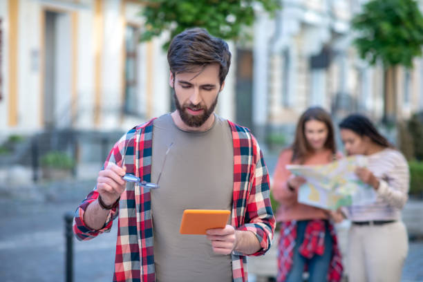 istock Focused young guy looking at tablet in the street 1255218910