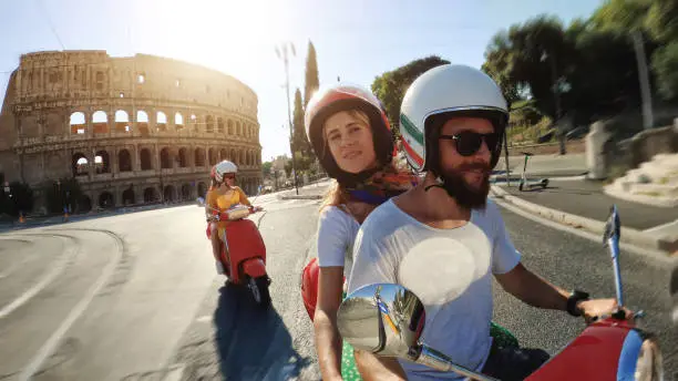 POV Selfie scooter riding: friends on the motorbikes in the center of Rome