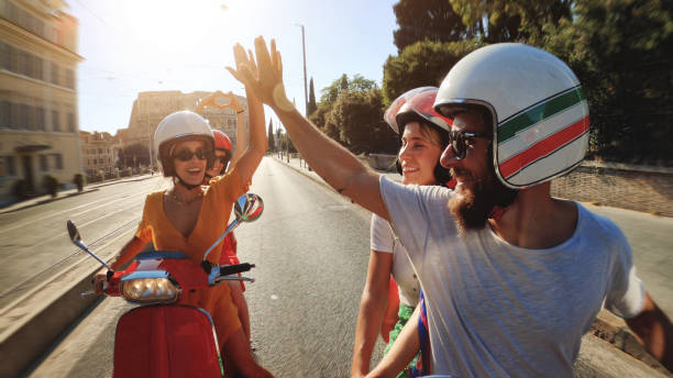 POV vintage scooter riding: friends on the motorbikes under the Coliseum of Rome POV Selfie scooter riding: friends on the motorbikes in the center of Rome motorized vehicle riding stock pictures, royalty-free photos & images