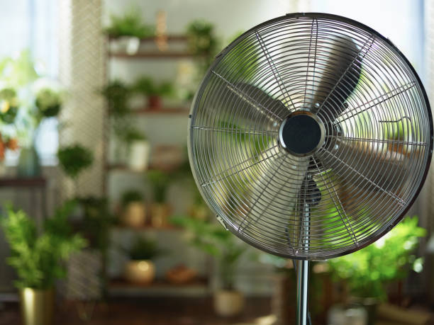 modern metallic floor stand electric fan Summer heat. modern metallic floor stand electric fan at modern home in sunny hot summer day. electric fan stock pictures, royalty-free photos & images