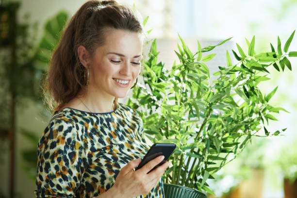 istock smiling woman using phone applications and decorating home 1255221031