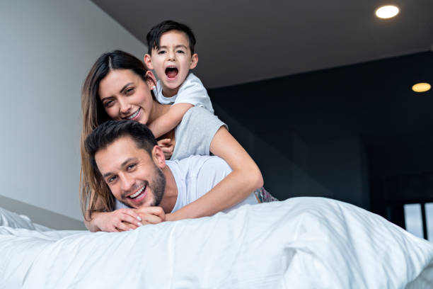 istock dad, mom and son play in bed 1255221779