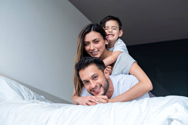 istock dad, mom and son play in bed 1255221857
