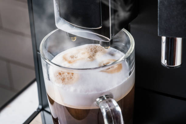 istock cup with hot cappuccino prepared in the coffee machine 1255226654