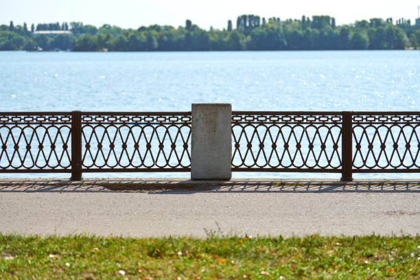 Iron fencing on waterfront. Riverside decor fence. Outdoor urban pathway for walking with enclosure