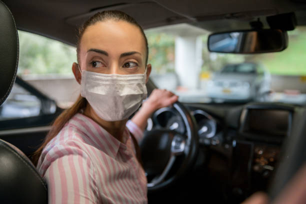 istock Woman going to work in her car wearing a facemask 1255226936