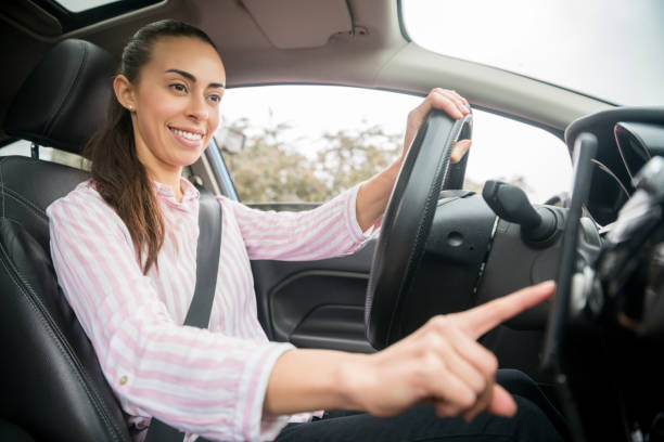 istock Happy woman using GPS on her cell phone while driving her car 1255226957
