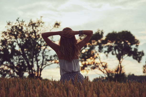 istock Young woman enjoying in a wheat field. 1255228410