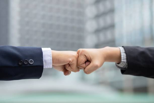 los empresarios se unen para hacer nuevos negocios juntos para crear rendimientos para los accionistas. - conflict competition arm wrestling business fotografías e imágenes de stock