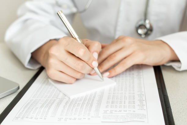 istock doctor writes a prescription while looking at test results 1255229511