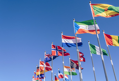 ondeando en las banderas de viento de diferentes países con cielo azul en el fondo photo