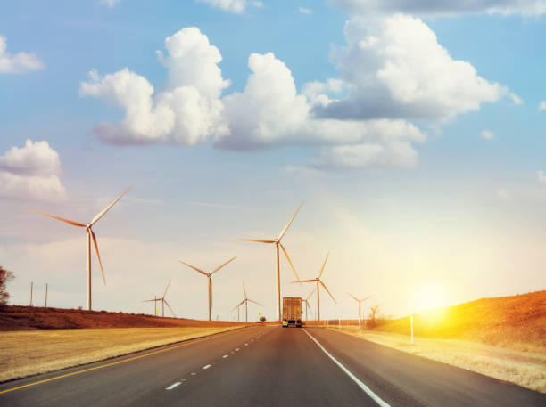 istock Wind turbines along highway at sunset 1255229584