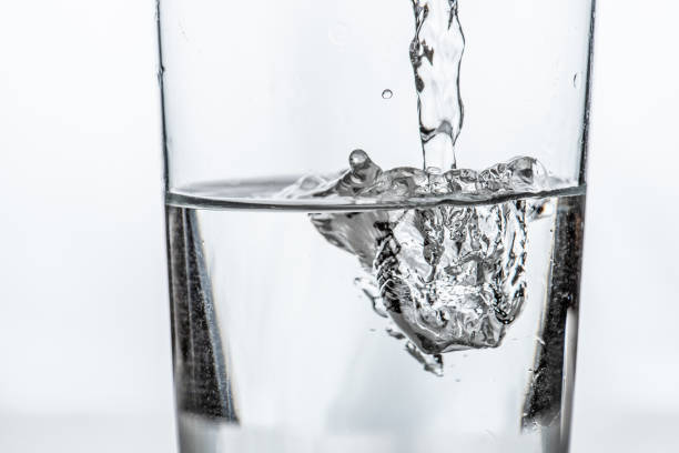 istock Water being poured into a glass. White background. 1255230033
