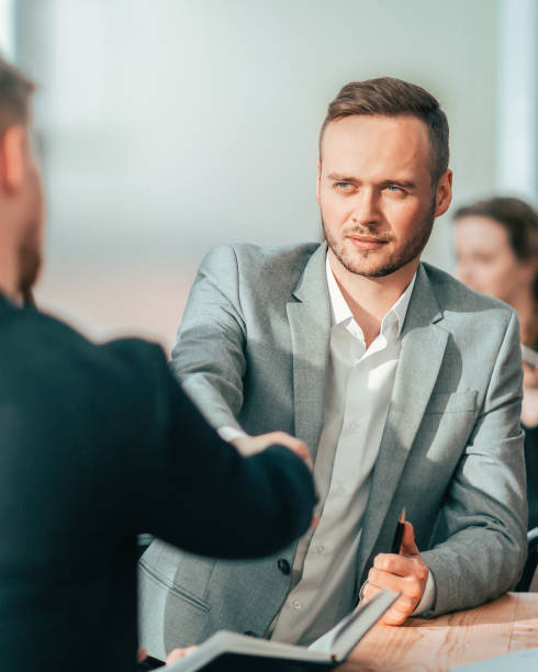 istock young businessmen confirm the deal with a handshake 1255230897