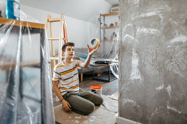 istock Boy is having fun while repainting the wall in his room 1255232245