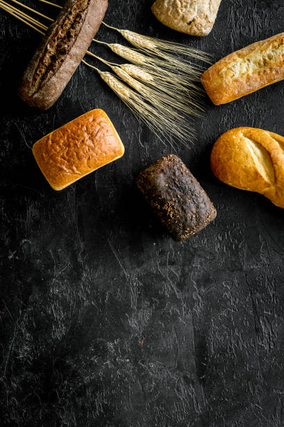 Set of loaves of bread on black desk from above copy space