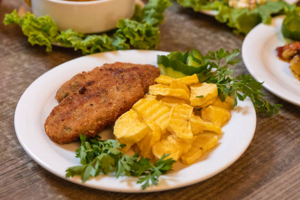 schnitzel mit bratkartoffeln - fish cutlet stock-fotos und bilder