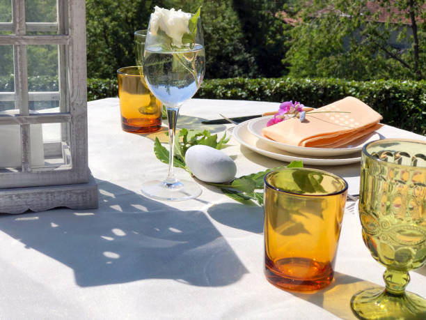 istock Served festive table. Wedding serving. White tablecloth with plates and decor in garden. Wedding concept. Catering services 1255236034