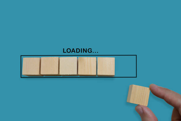 istock Hand putting wood cube in progress bar on blue background. 1255236403