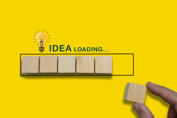 istock Hand putting wood cube in progress bar on yellow background. 1255236458