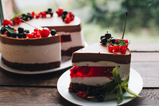 istock Mousse cake with berries on a wooden table. Chocolate cream cake with currants and cherries. Berry cake for birthday, wedding and other holidays. 1255238065
