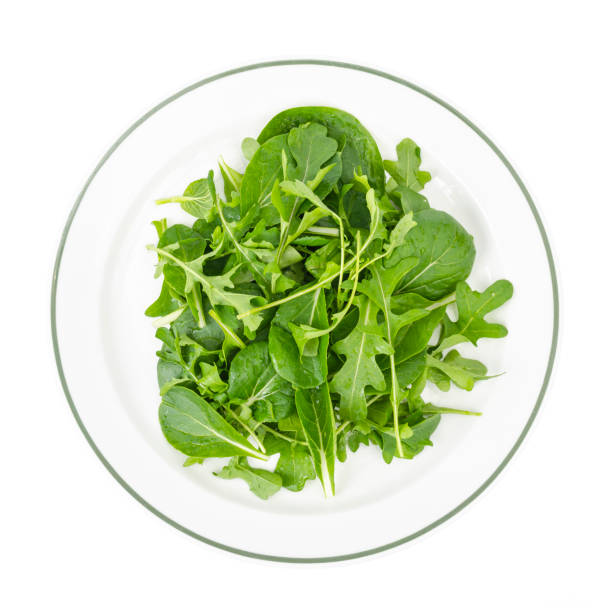 istock Healthy eating Arugula and spinach leaves on white plate, vegetarian menu 1255241718