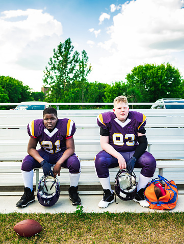 Two Junior Football players getting ready for practice at the outdoor field.