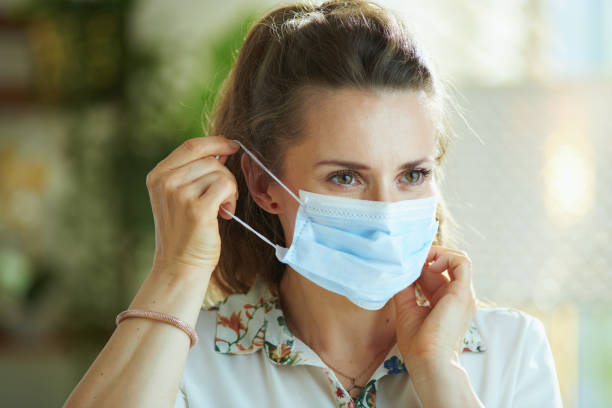 istock trendy female in white blouse wearing medical mask 1255242593