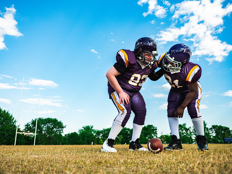 Two Junior Football players during practice game at the outdoor field.