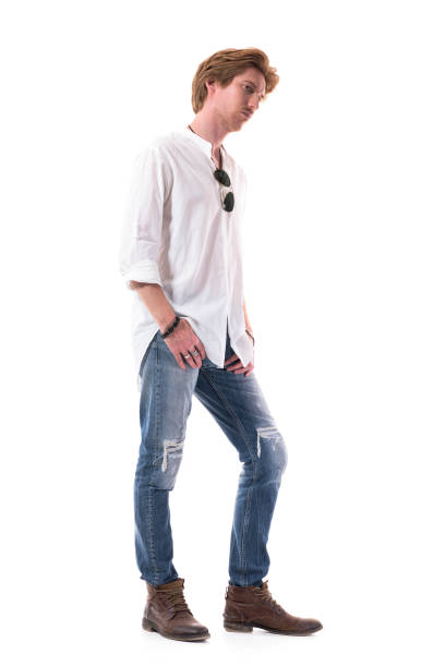 istock Thoughtful young serious man in jeans and white shirt looking away interested. 1255243790