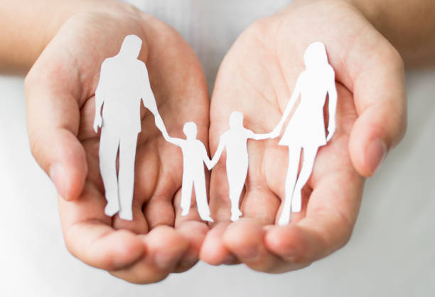 istock Paper family in hands isolated on white background 1255246630