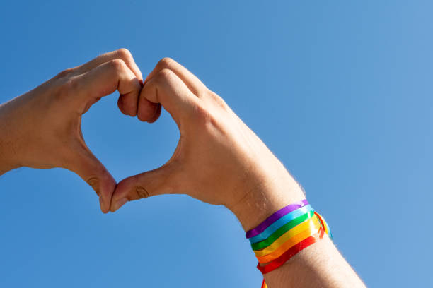 segno di cuore con orgoglio gay braccialetto bandiera arcobaleno lgbt - gay pride wristband rainbow lgbt foto e immagini stock