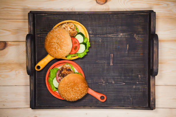 Two homemade hamburgers with fresh vegetables and chicken cutlets.