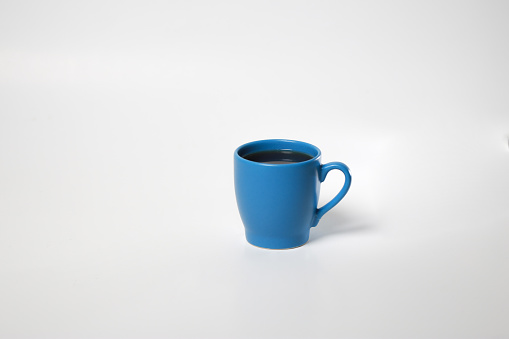 blue coffee cup with coffee in background isolated on white