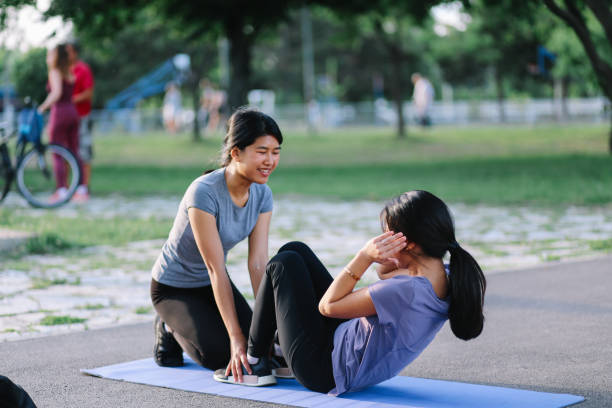 istock Young woman exercising with a personal trainer 1255253084