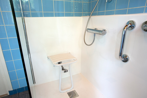 Handicapped disabled shower chair for elderly or disabled people with handle bar in senior home, safety concept closeup