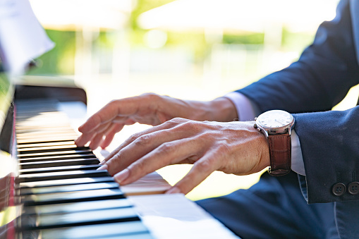 Hands of a classical musician playing piano, outdoors concert