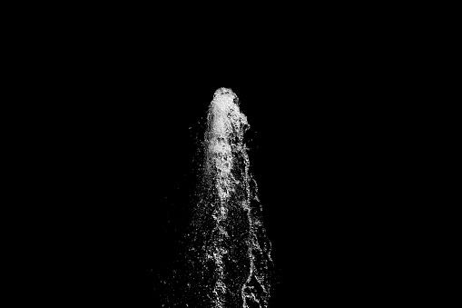 water jet rising up and splashing on a black background