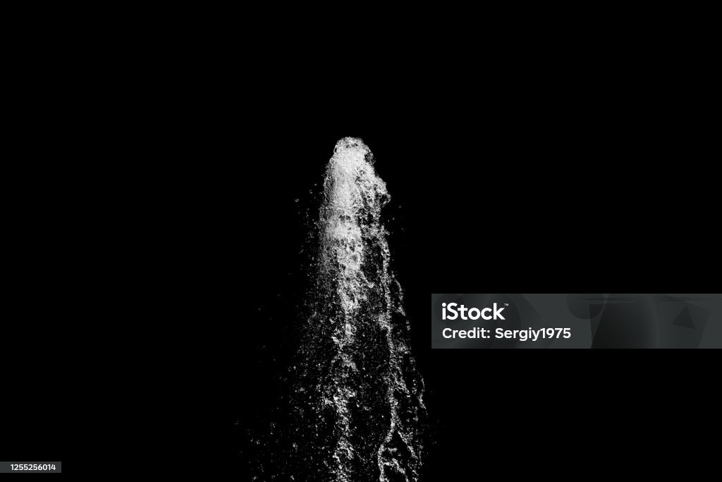 water jet rising up and splashing on a black background water jet rising up and splashing on a black background, abstract Fountain Stock Photo