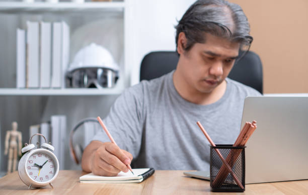 istock Asian Businessman are working at home at night To solve business problems After being affected by the lockdown. Concept of business planning, vision, and mission to cope with the economic crisis 1255257579