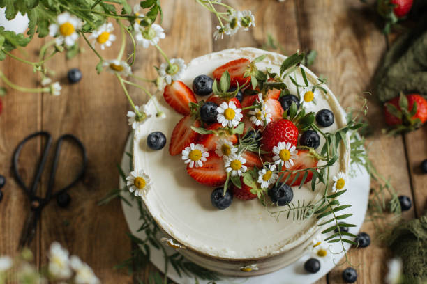 na stole jest ciasto ozdobione kwiatami i jagodami - berry fruit blueberry floral pattern strawberry zdjęcia i obrazy z banku zdjęć