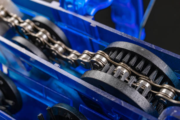 istock Cleaning the bicycle chain with a device. Small works in a bicycle workshop. Dark background. 1255260348