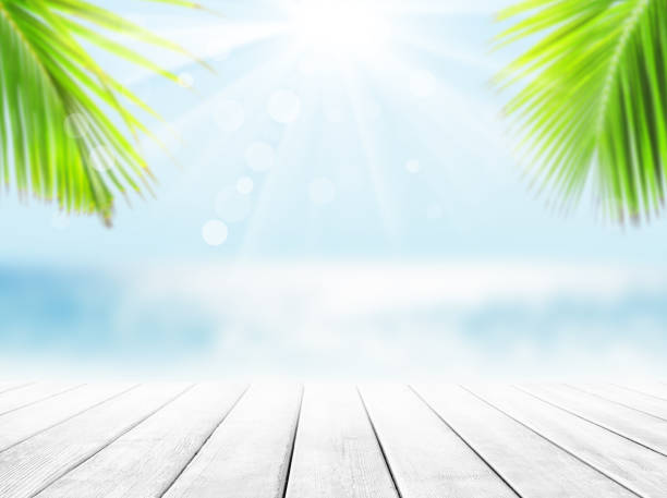 istock Wooden table top on blue sea and white sand beach background. 1255263659