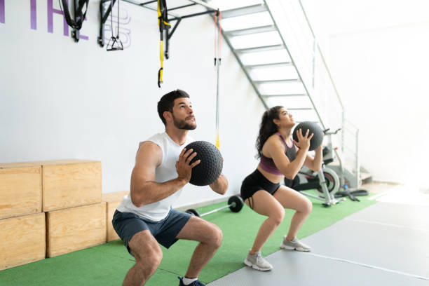 istock Young Hispanic Couple Doing Wall Ball Exercise 1255263997