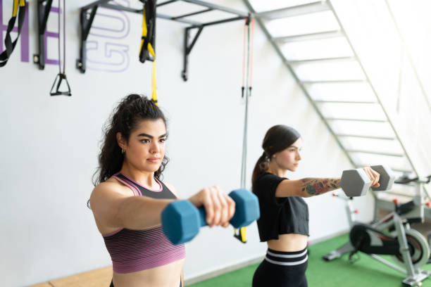 istock Determined Latin Women Working Out With Dumbbells 1255264022